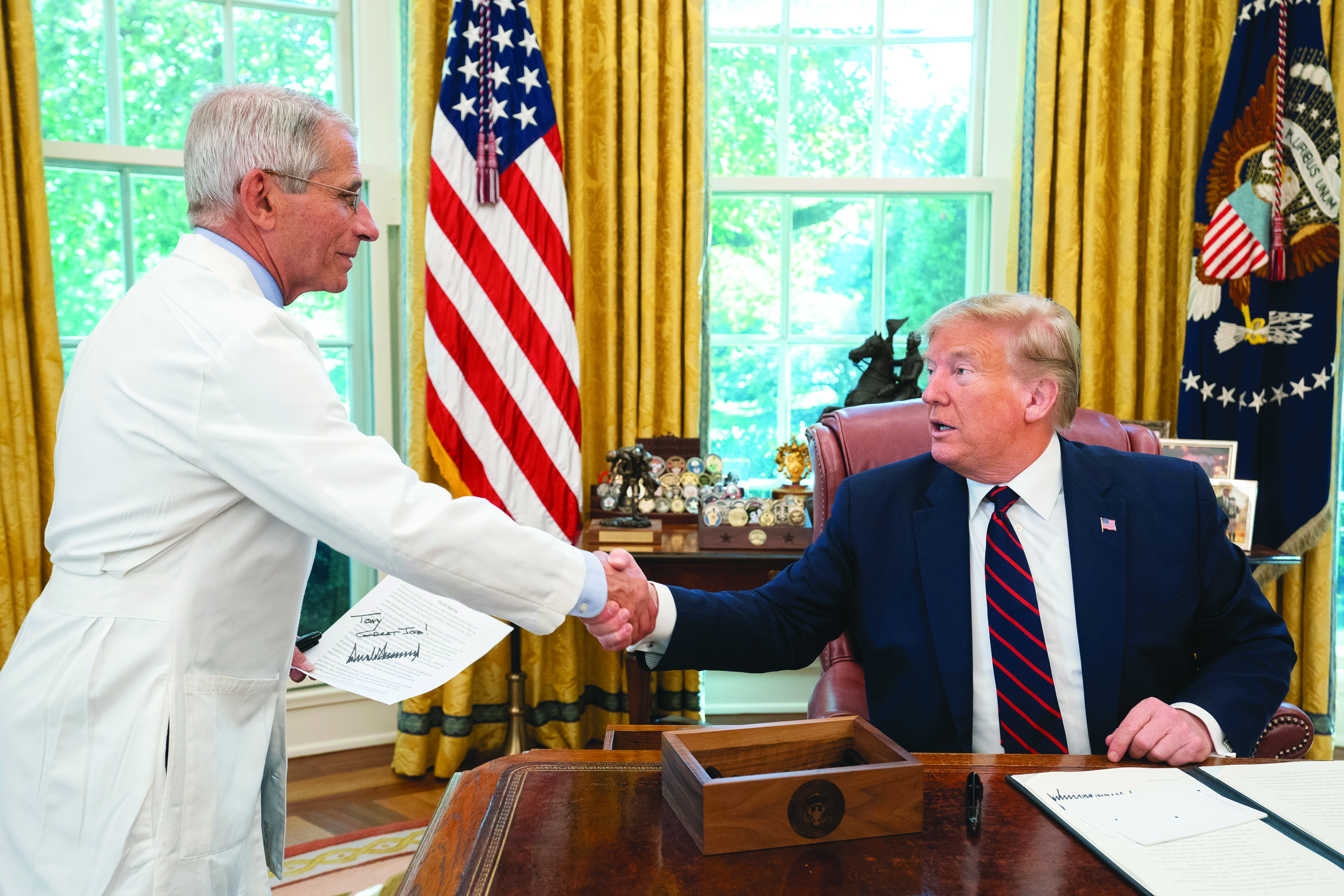Fauci shaking hands with President Donald Trump in the Oval Office after signing an executive order for flu vaccines in September 2019.