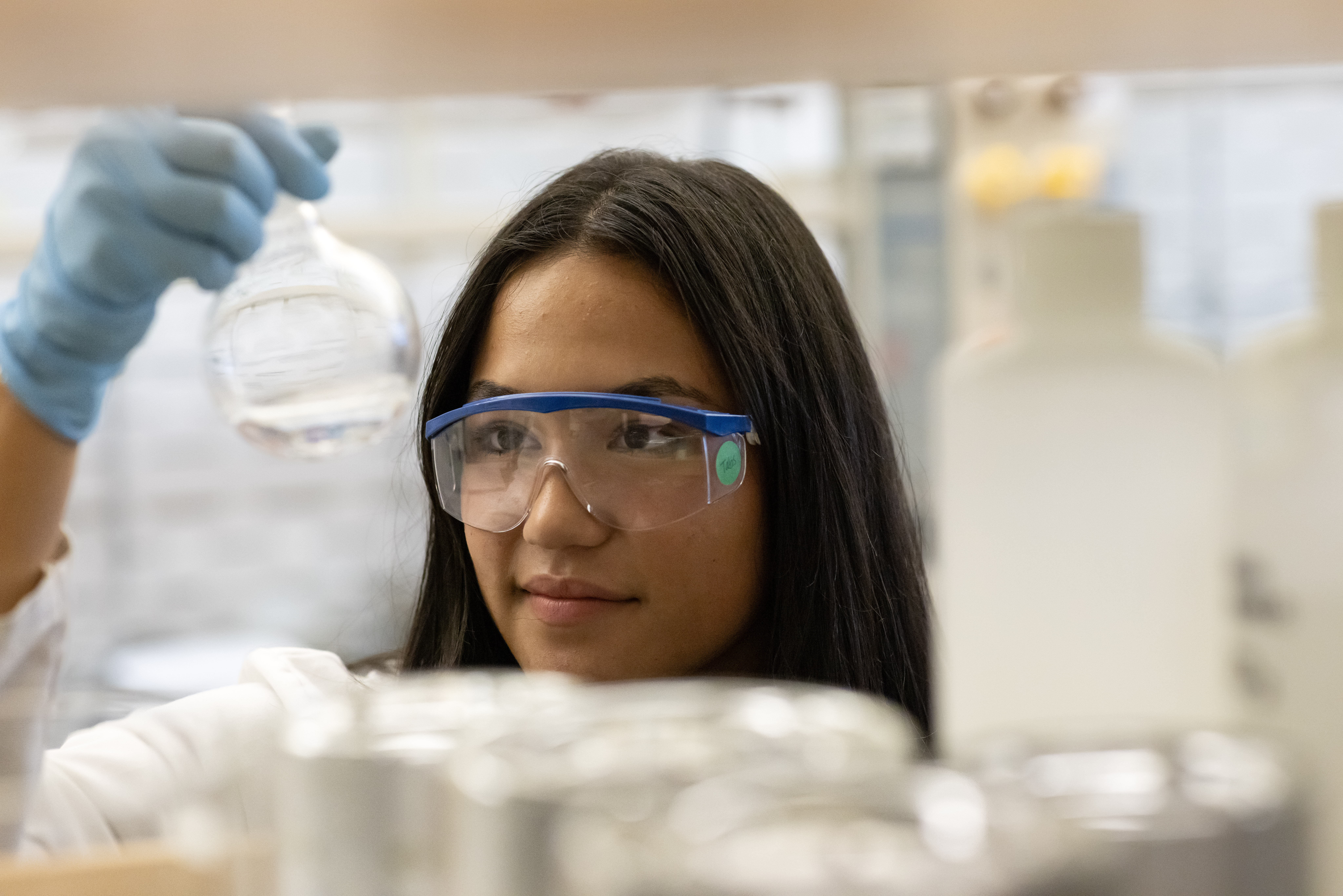A science student studies a vial