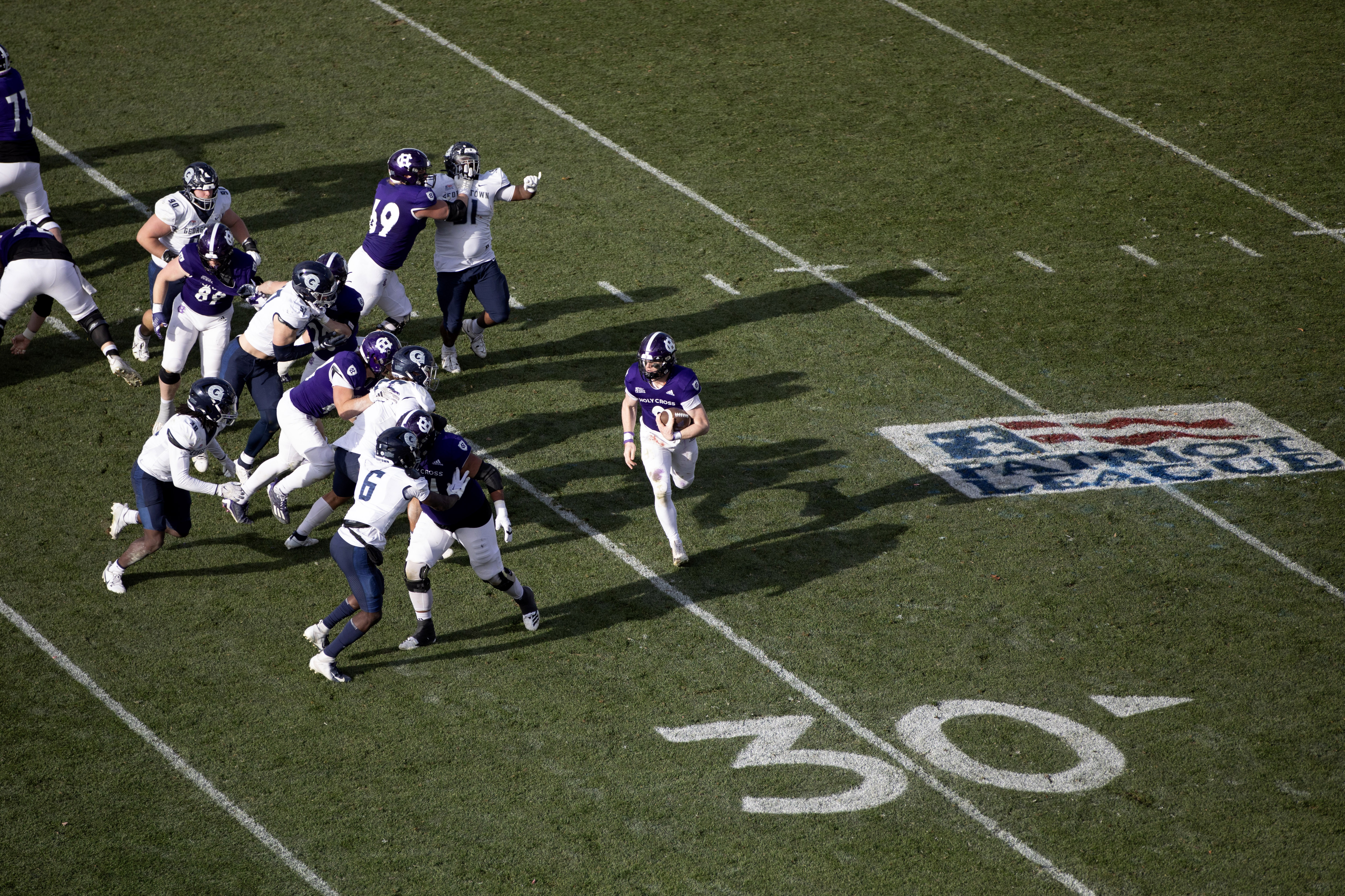 a view from above of a quarterback rushing with the football