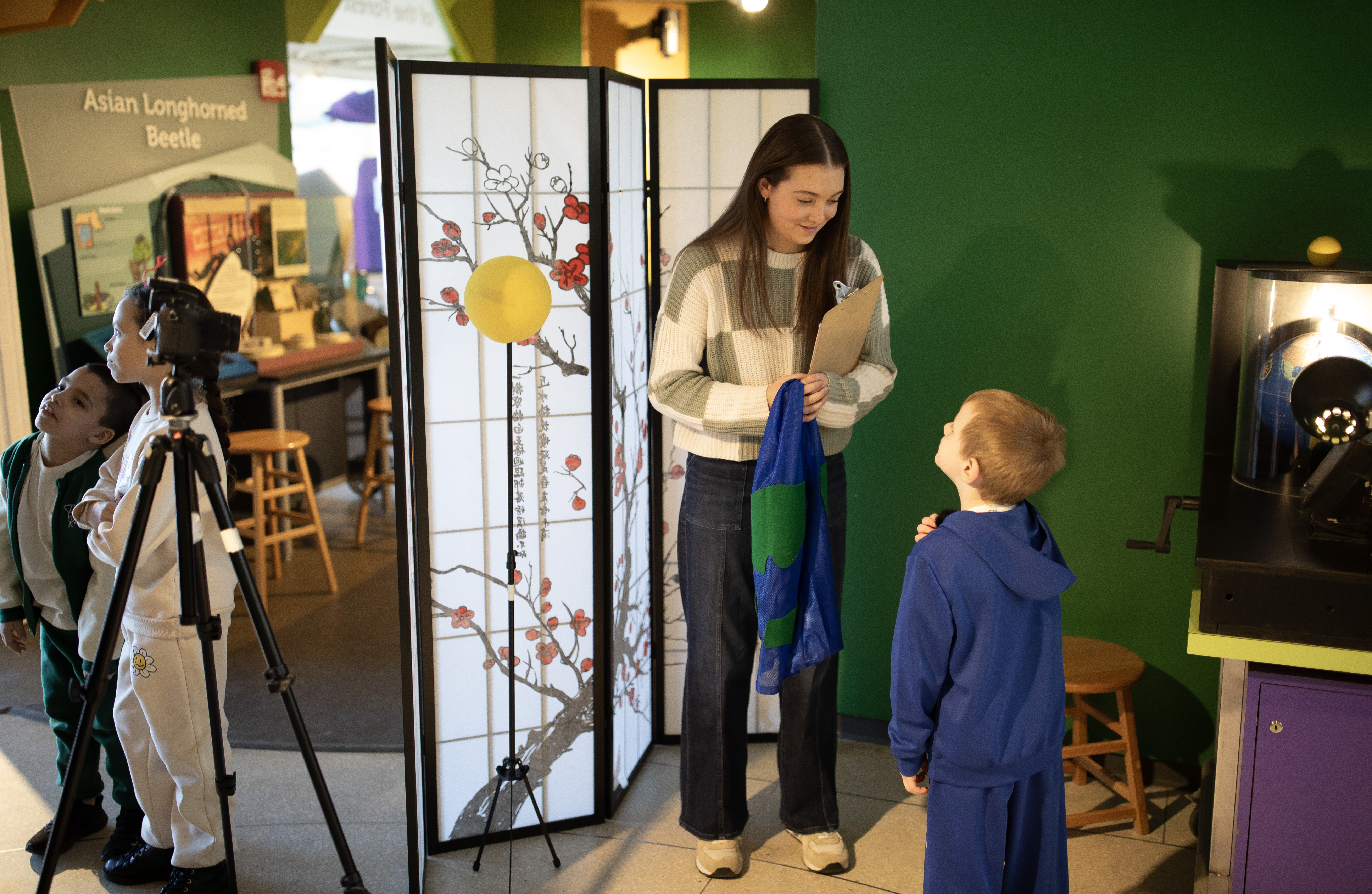 Female college student smiles at a small boy.