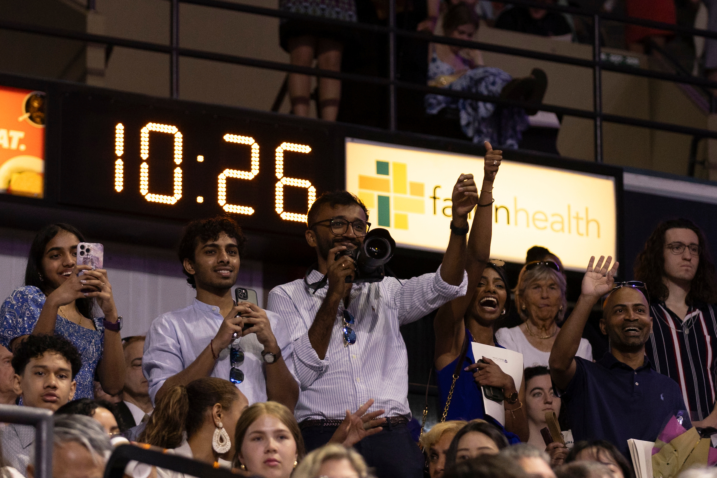 Parents cheering for students during a college commencement.