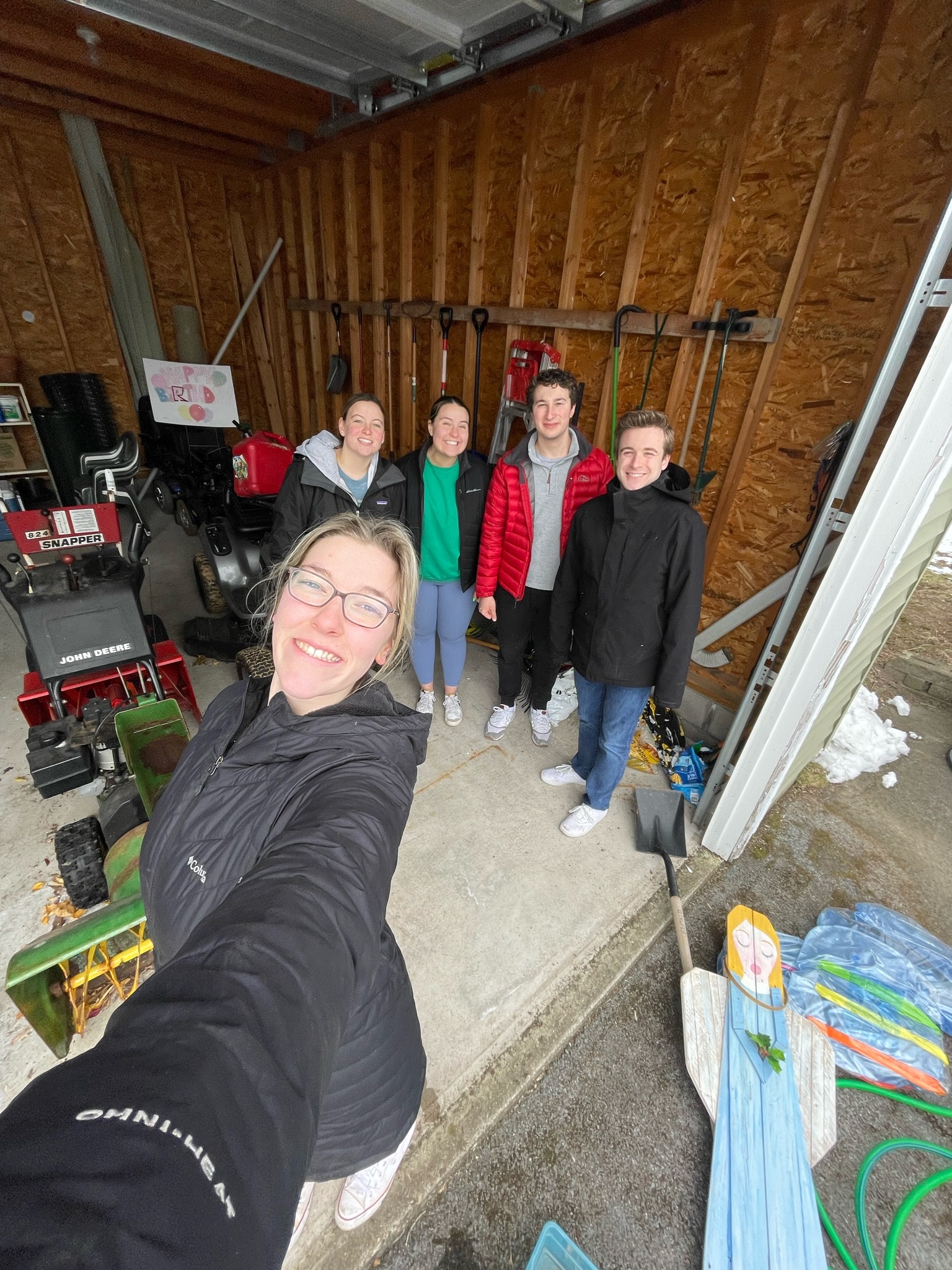 A group of young people taking a selfie together inside a shed