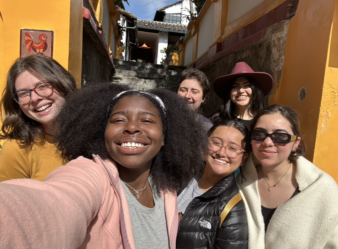 A group of friends huddled together smile while taking a selfie