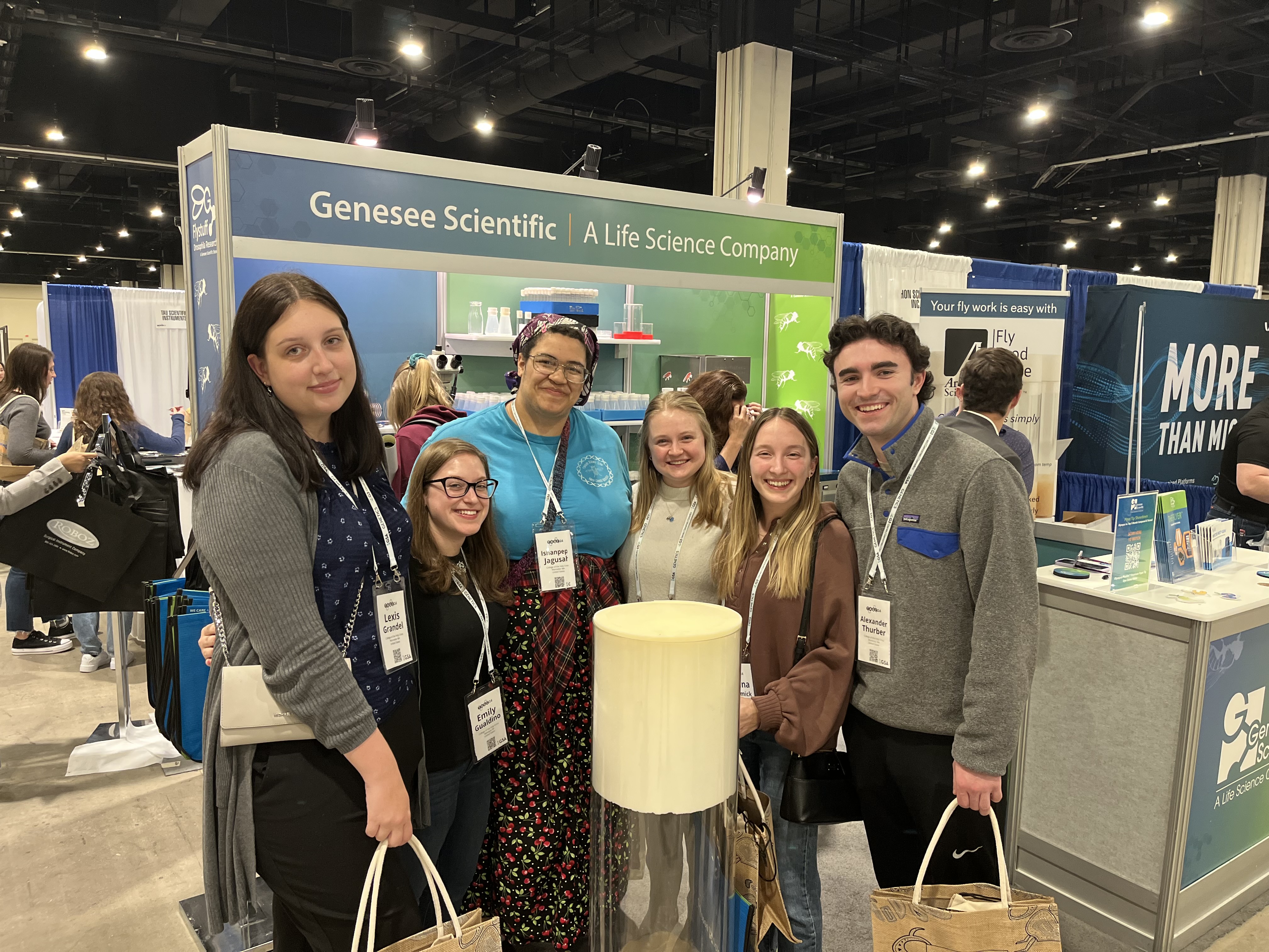 Students gathered for a posed picture in front of a scientific poster presentation.