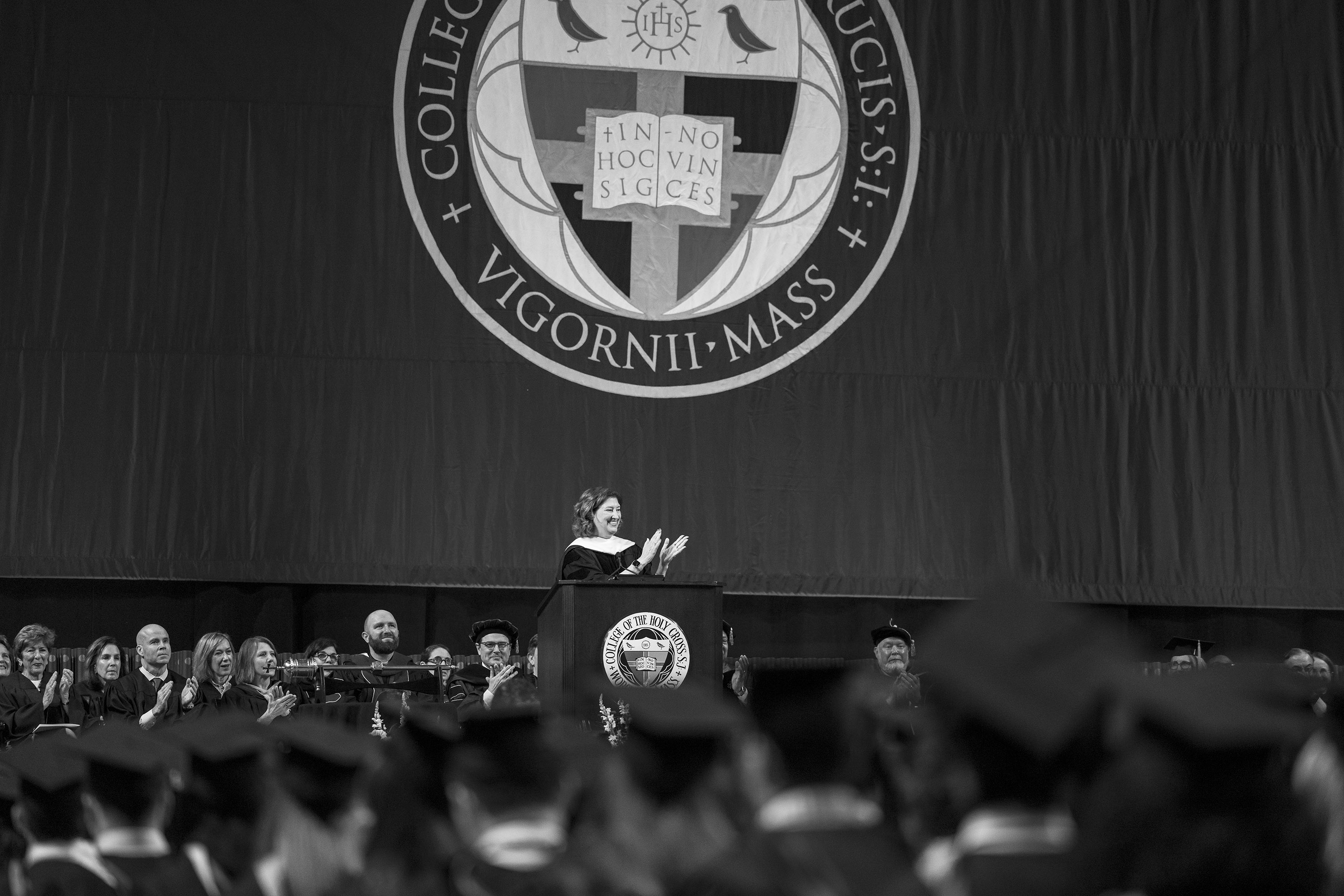 A woman delivers an address to a crowd of college grads