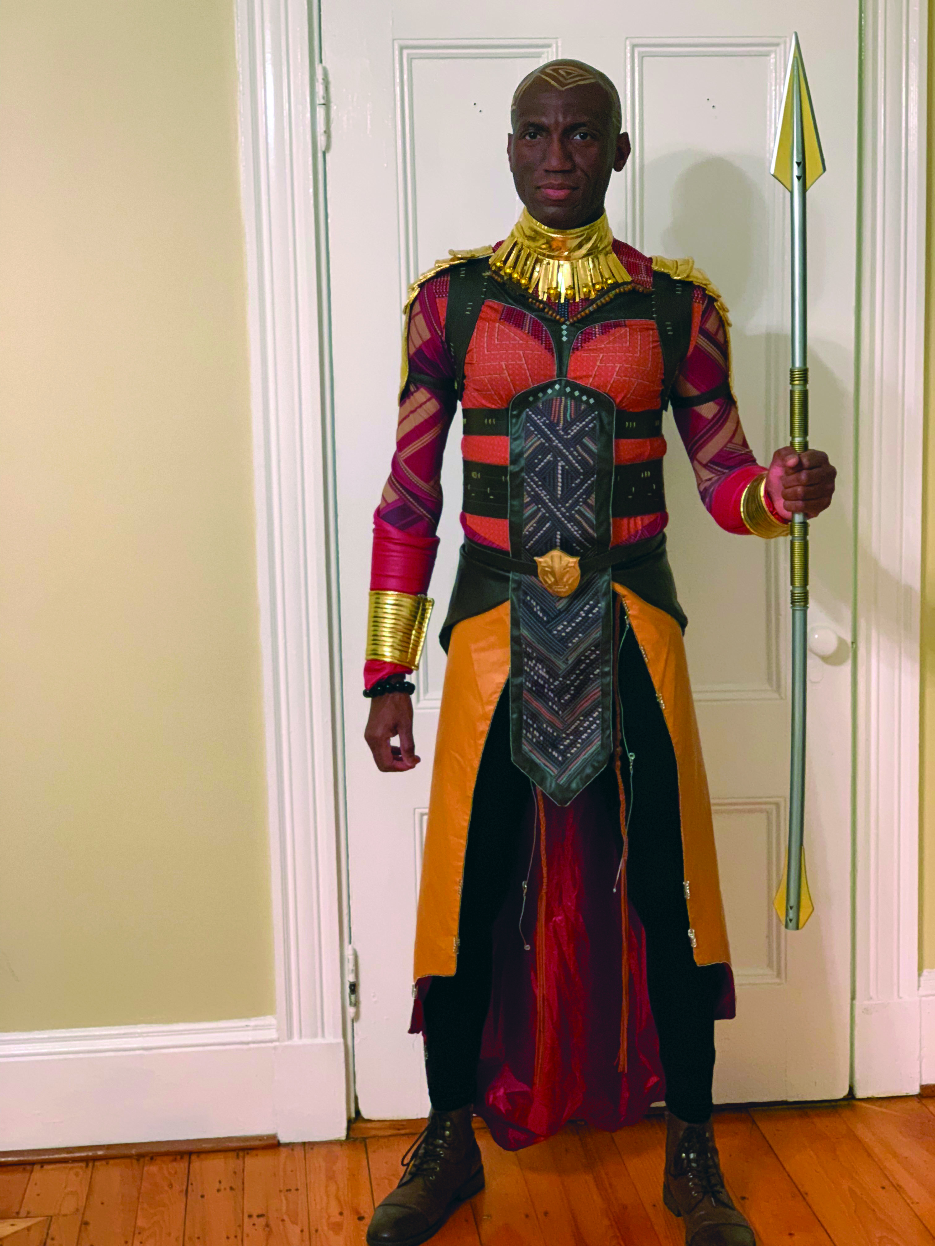 André Isaacs holding a spear in his left hand in dressed as a warrior from &quot;Black Panther&quot;