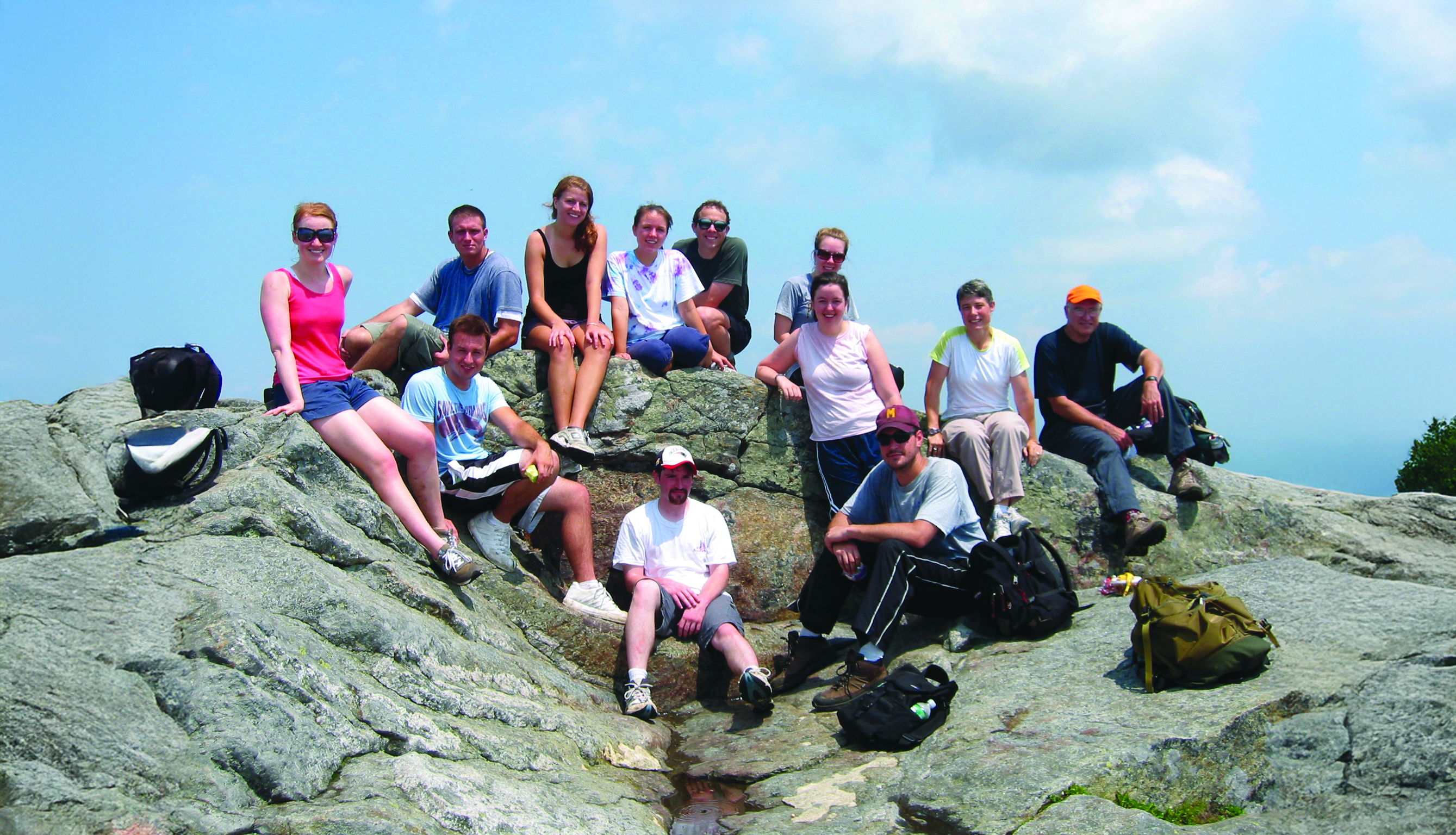 Group of people sit on a mountain peak