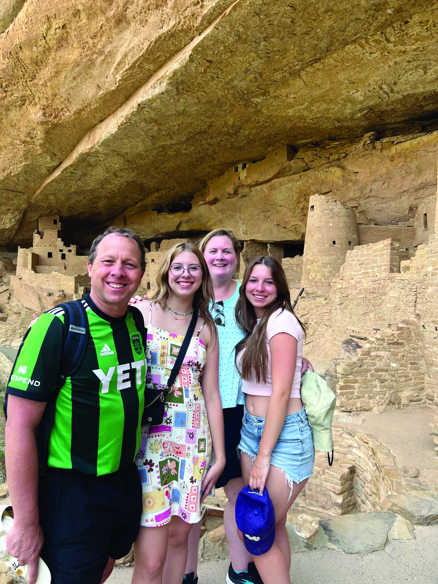 Four people stand near rock formation