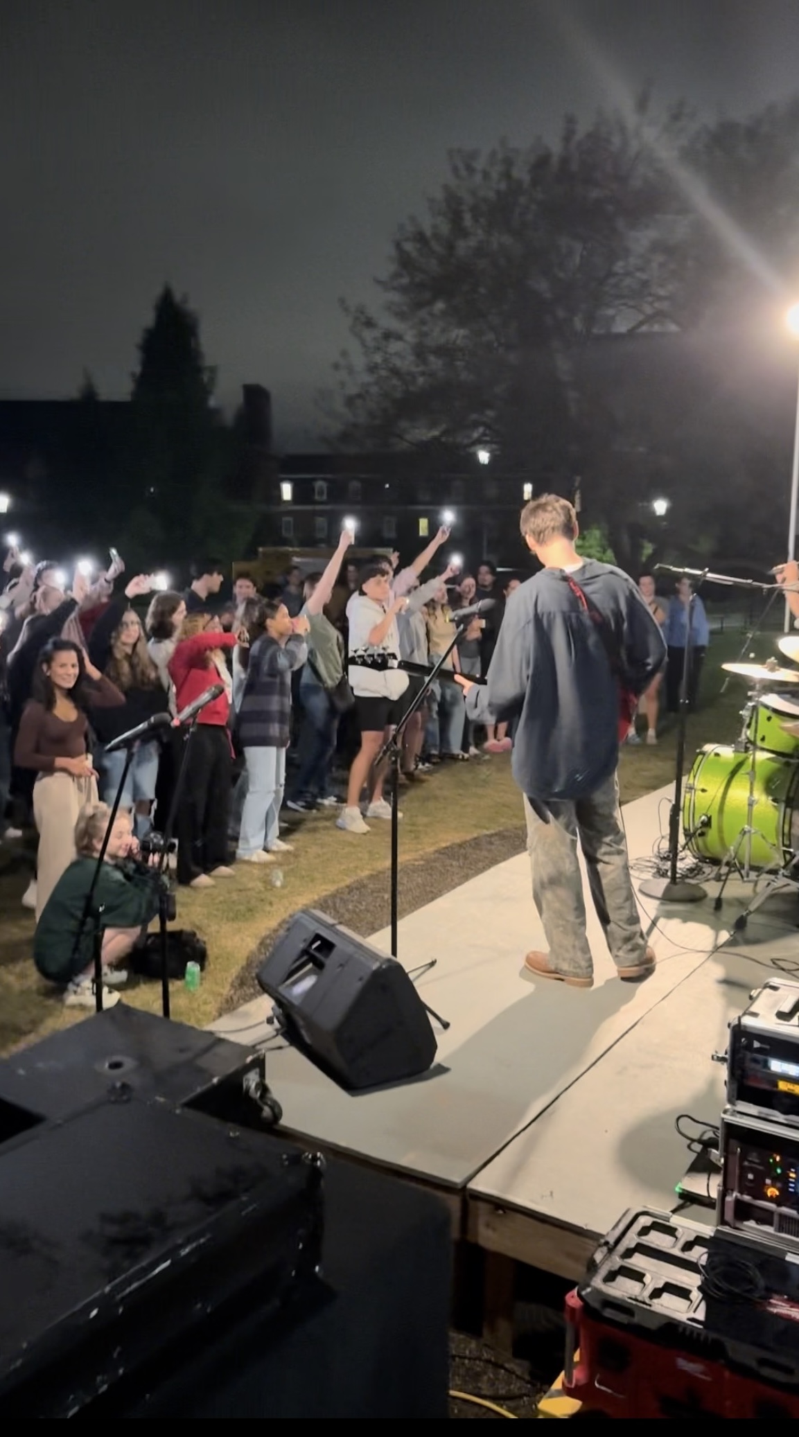 Benjamin facing a sea of flash lights as Razzberry Jam performs their first original song at Fall Band Night (2024)