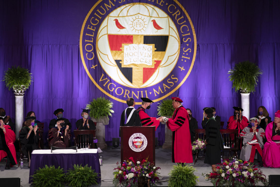 President Vincent Rougeau receiving the mace from President Emeritus Rev. Philip L. Boroughs, S.J. Photo by Matt Wright