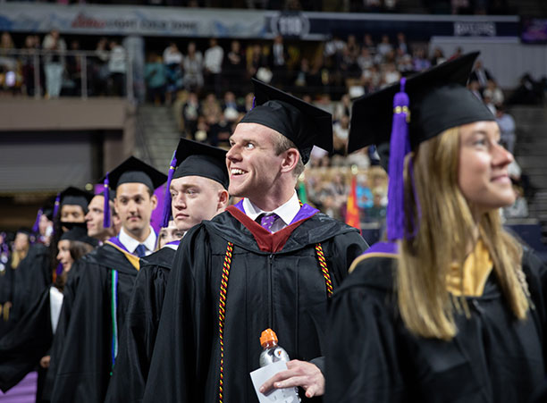 Students look out into the crowd as they process.