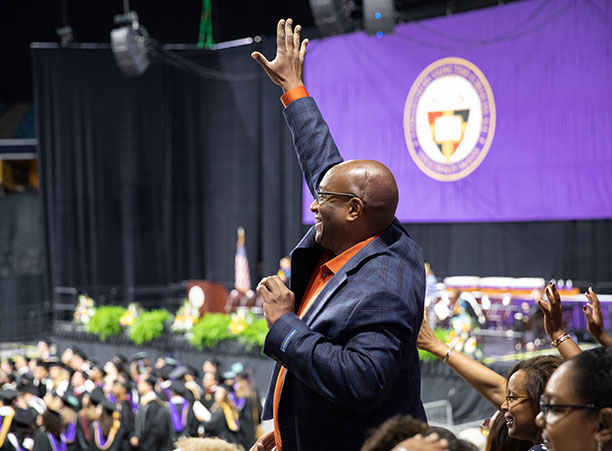 A family member waves from the crowd.