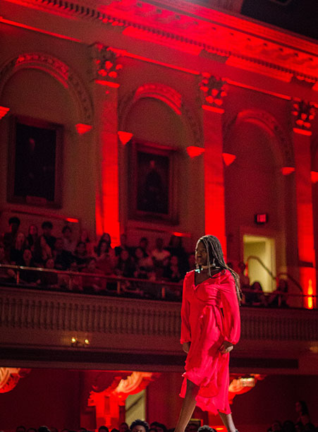 A student walks down the runway during the red scene of the BSU 20th Annual Fashion Show.