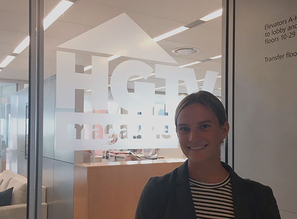 A student stands in front of a sign for HGTV Magazine