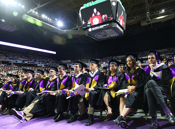 Graduates watch Rev. Philip L. Boroughs, S.J. speak.