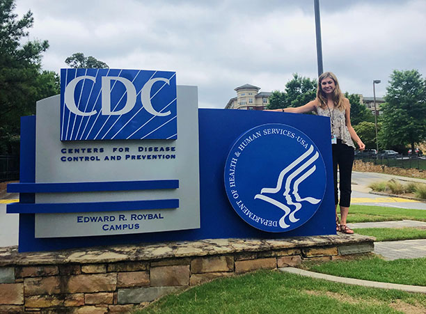 A student stands next to a sign for the CDC