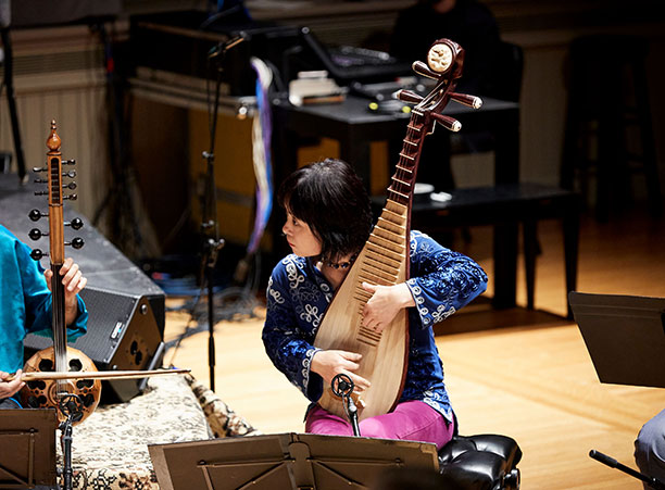 A woman plays a string instrument