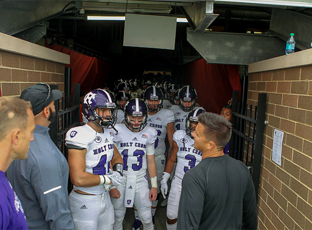 holy cross football players walk onto field