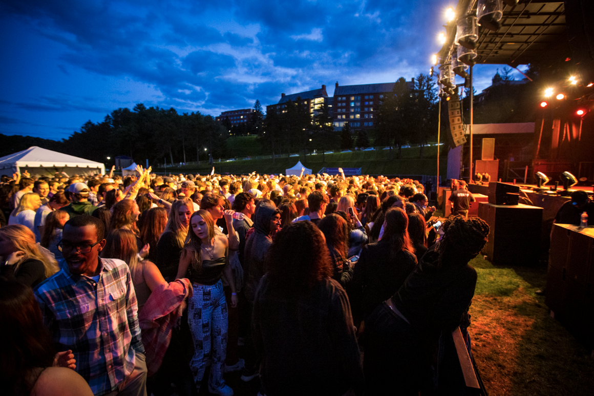 Students watch a concert in a crowd on campus.