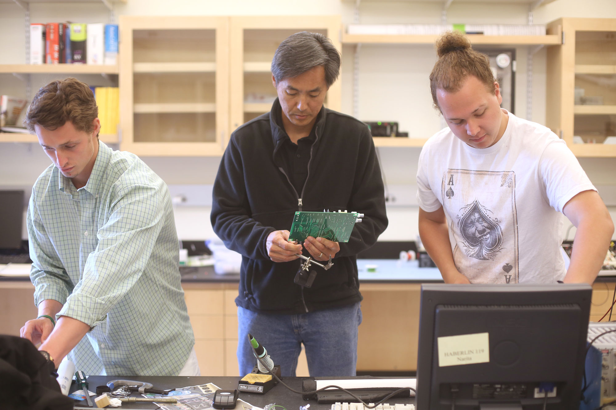 Physics majors Samuel Habein ‘17 and James Harrison ’16 work with Tomohiko Narita, associate professor of physics, to build a telescope to detect cosmic rays.