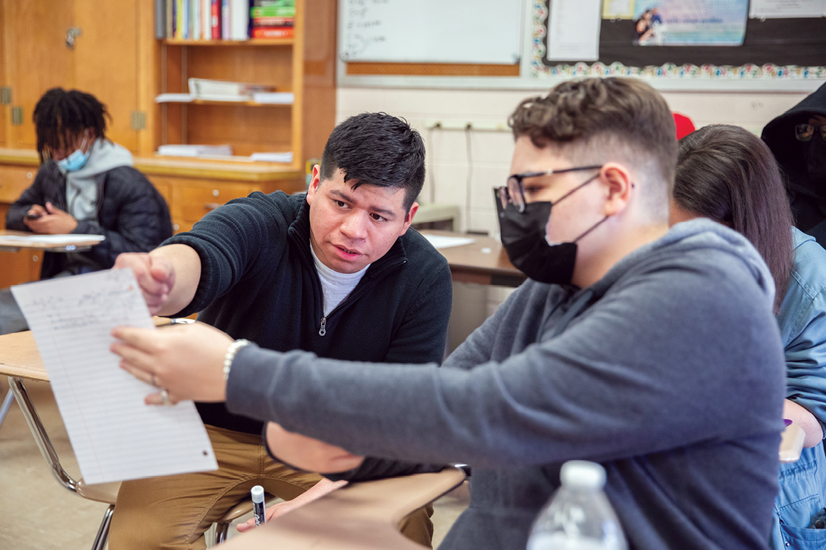 Josh Delgado '15 is reviewing classwork with a student from his Honors Algebra II class.