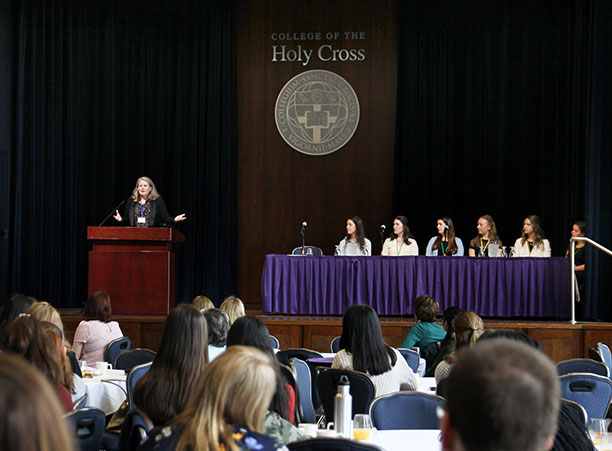 A speaker stands on stage in front of a crowd