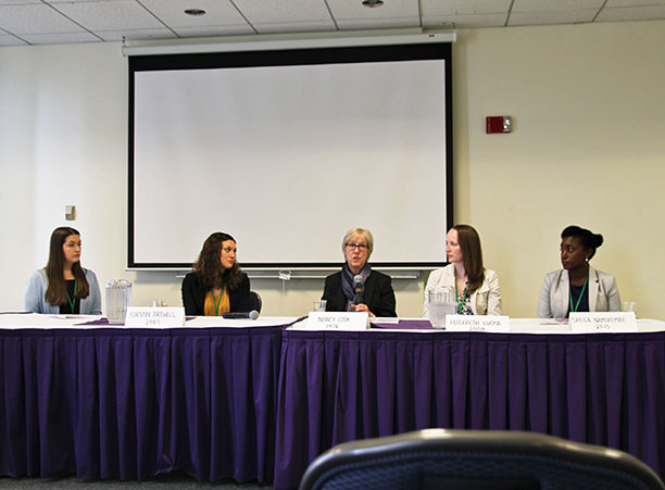Five women sit at a long table