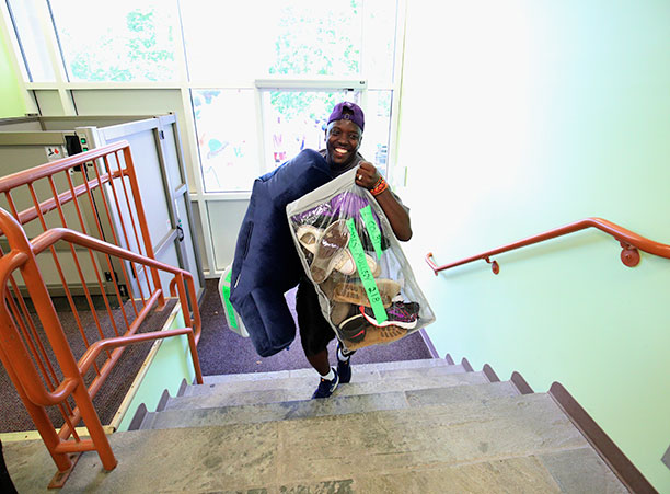 a faculty member carries a box up stairs