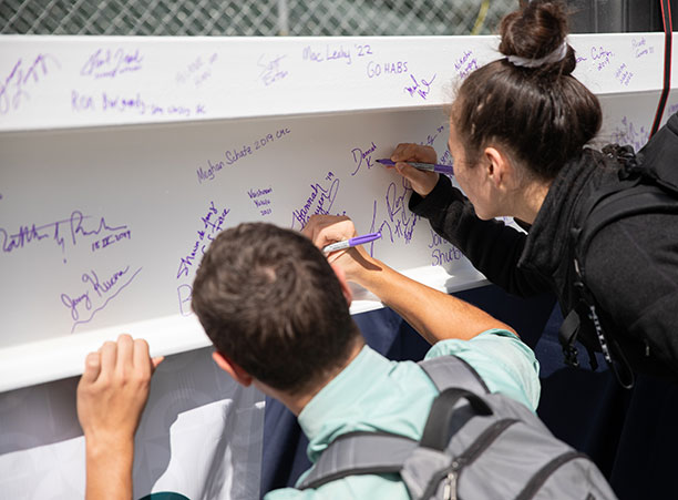Students sign a beam