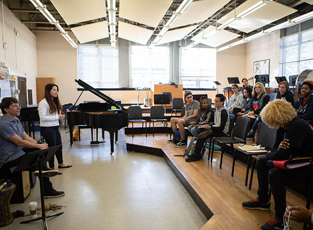 Two musicians talk to a classroom of students