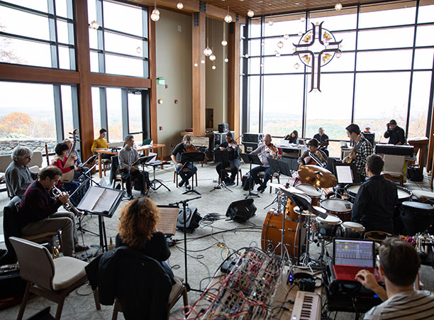 Musicians plan their instruments in a large, open space