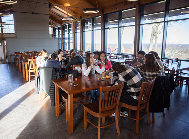 A group of students sit at a table and do arts and crafts