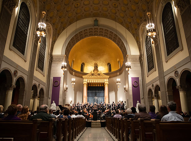 A wide-angle shot of St. Joseph Memorial Chapel with music being performed in the front