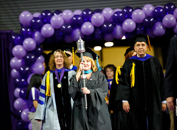 Patricia Ring, registrar, carries the college mace to lead the processional.