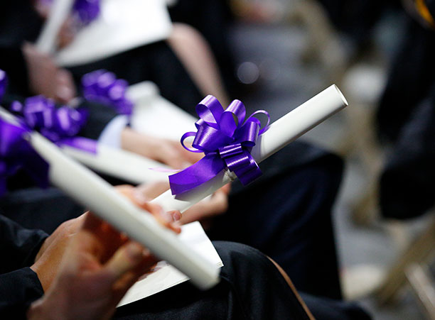 A student holds their diploma.