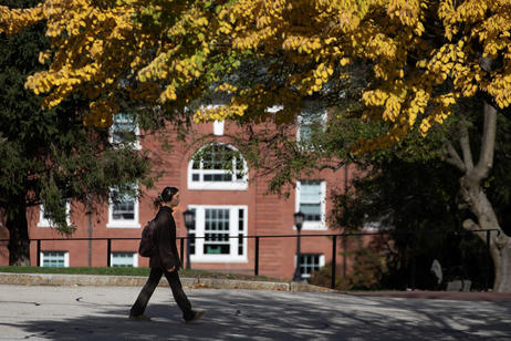 Student walks by brick building