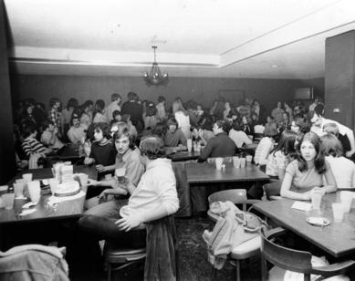 A large group of people within a dining hall or cafeteria