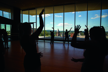 Students practice dance in an indoor studio.