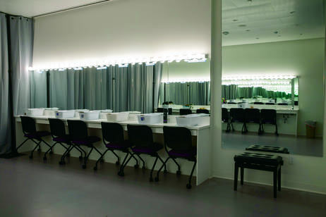 A row of chairs sitting in front of a wall of mirrors.