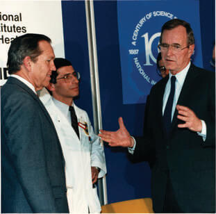 President George H.W. Bush talks with Fauci at the NIH’s 100th anniversary event in 1987.