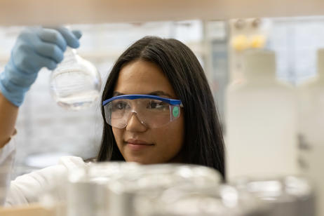A science student studies a vial