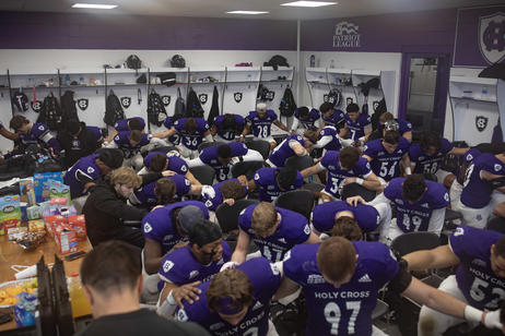 Football players pray in the locker room before a game
