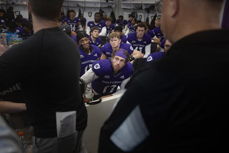 Football players pray in the locker room before a game