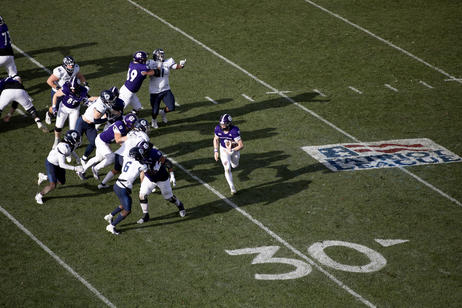 a view from above of a quarterback rushing with the football