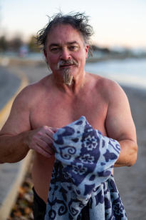 Man in bathing suit holding towel