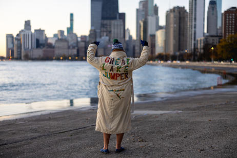Man in robe flexes in front of city skyline