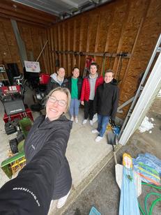 A group of young people taking a selfie together inside a shed