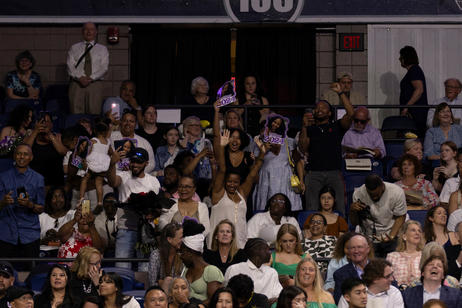 Families cheer on graduates during commencement ceremony.