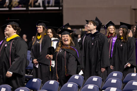 Soon-to-be college graduates line up to walk into commencement ceremony.