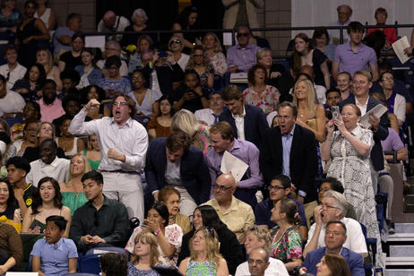Parents cheer for graduating seniors as the students walk into commencement ceremony.